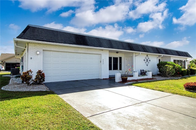 ranch-style house with cooling unit, a front yard, and a garage