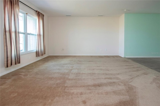 spare room featuring light carpet