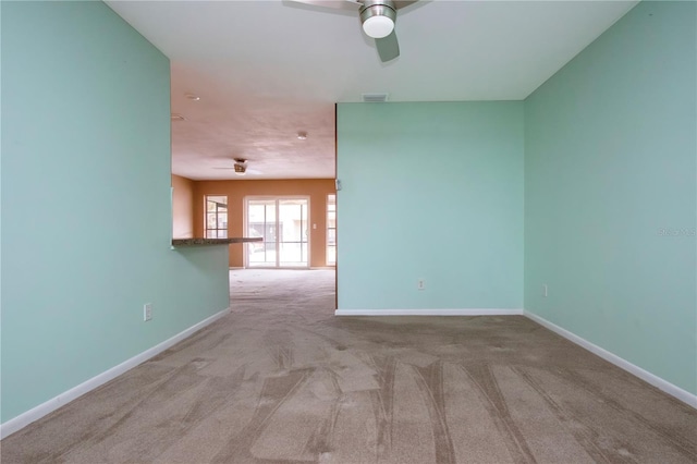 carpeted spare room featuring ceiling fan