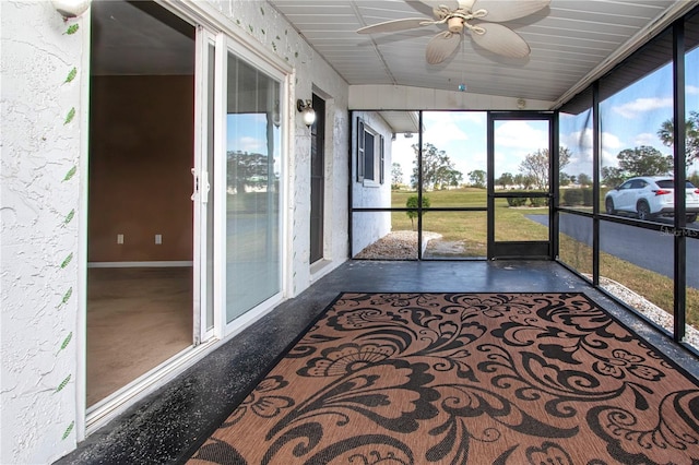 unfurnished sunroom with ceiling fan and vaulted ceiling