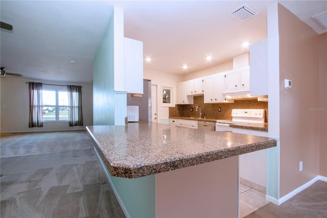 kitchen with white range, decorative backsplash, sink, white cabinetry, and carpet flooring