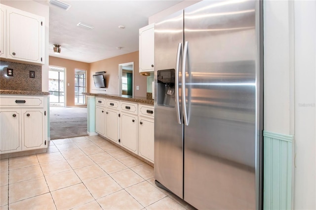 kitchen with white cabinetry, dark stone counters, and stainless steel refrigerator with ice dispenser