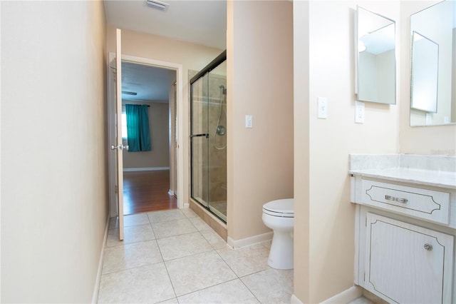 bathroom with vanity, toilet, tile patterned floors, and a shower with door