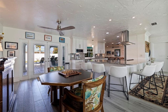 dining room with ceiling fan, french doors, sink, a textured ceiling, and light wood-type flooring