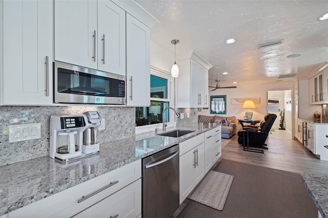 kitchen featuring white cabinets, sink, stainless steel appliances, and dark wood-type flooring