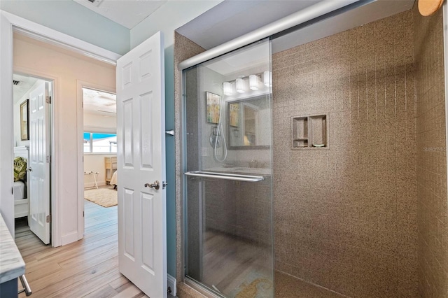 bathroom with a shower with door and wood-type flooring