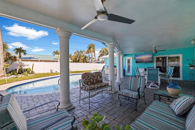 view of patio / terrace with a fenced in pool and ceiling fan