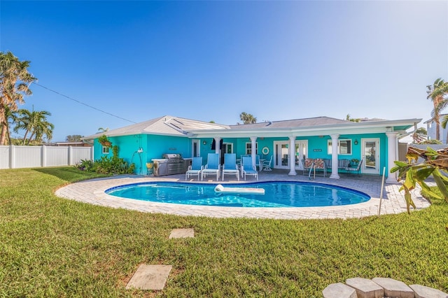 view of pool with a lawn, a patio area, and french doors