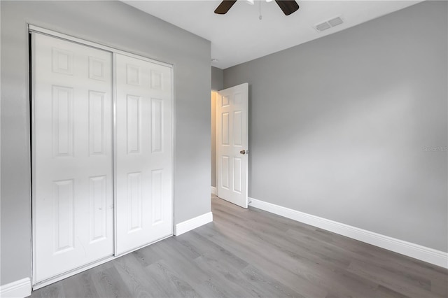 unfurnished bedroom featuring light hardwood / wood-style flooring, a closet, and ceiling fan