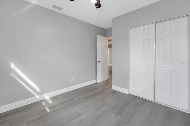 unfurnished bedroom featuring light wood-type flooring, a closet, and ceiling fan