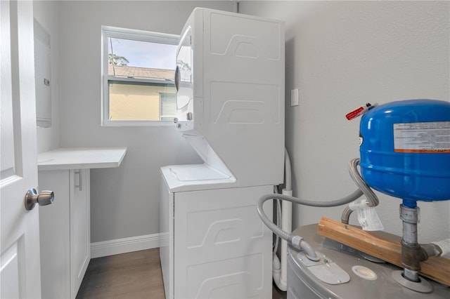 laundry area featuring hardwood / wood-style floors and stacked washing maching and dryer