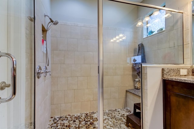 bathroom with vanity and a shower with door