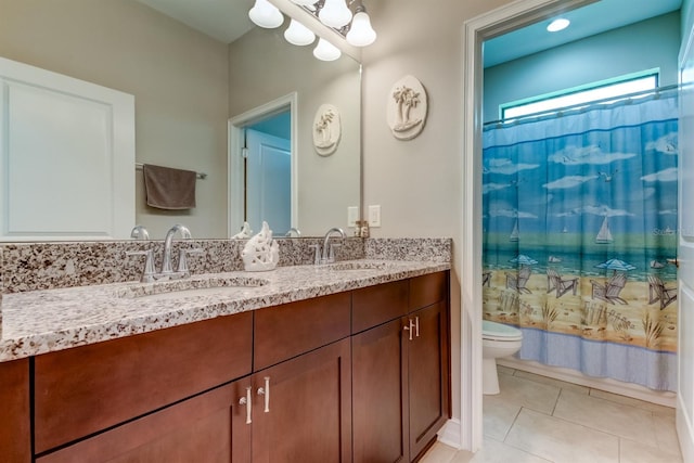 bathroom with toilet, vanity, and tile patterned floors