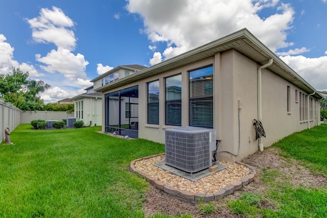 rear view of property featuring central AC unit and a yard