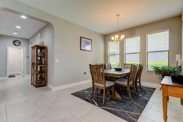 tiled dining room with an inviting chandelier