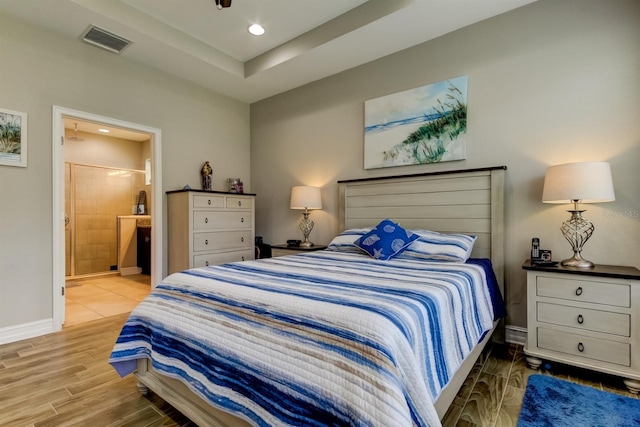 bedroom featuring light hardwood / wood-style floors and connected bathroom