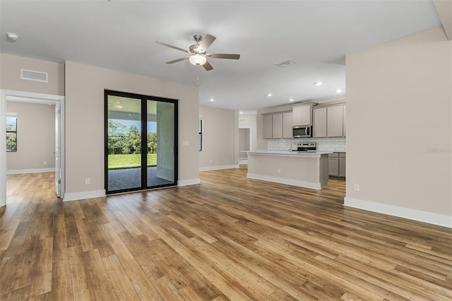 unfurnished living room featuring ceiling fan and light wood-type flooring