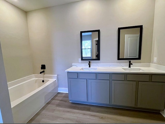 bathroom featuring a tub to relax in, wood-type flooring, and vanity