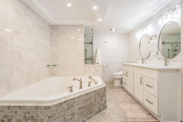 full bathroom with toilet, shower with separate bathtub, vanity, and tile walls