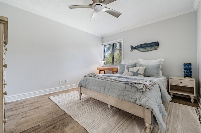 bedroom with crown molding, hardwood / wood-style flooring, and ceiling fan