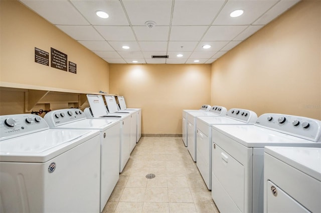 clothes washing area with light tile patterned flooring and washer and dryer