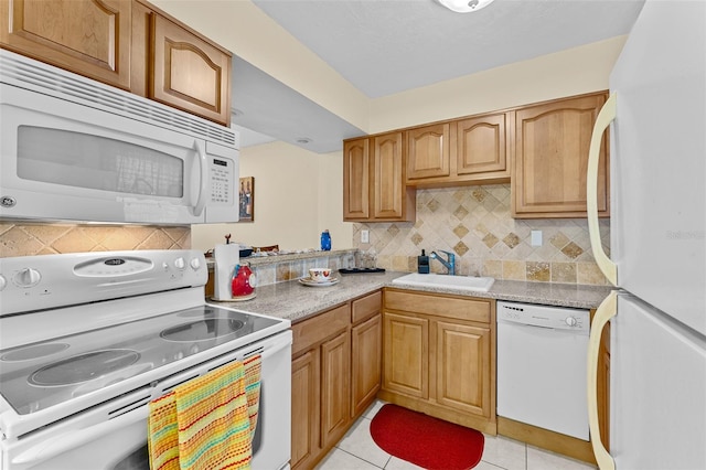 kitchen with white appliances, backsplash, light tile patterned flooring, and sink