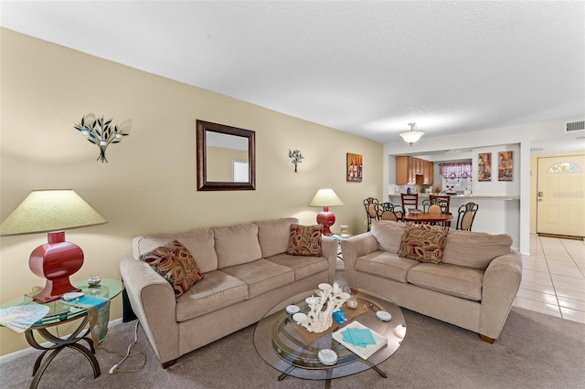 living room featuring a textured ceiling and light tile patterned floors