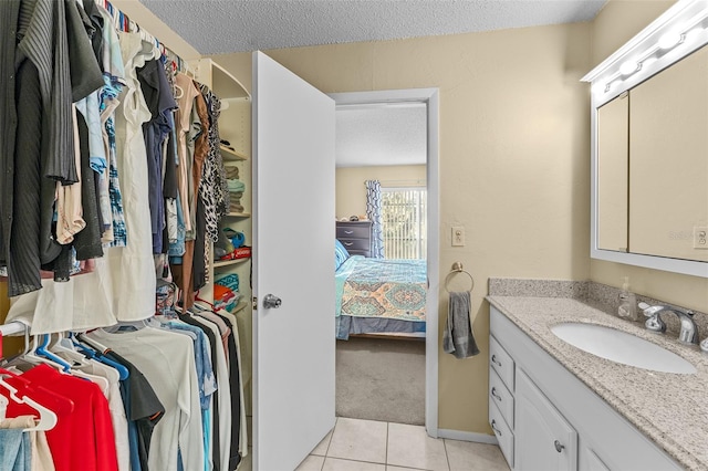 bathroom with vanity, a textured ceiling, and tile patterned flooring