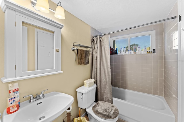 full bathroom with sink, shower / bath combination with curtain, and toilet