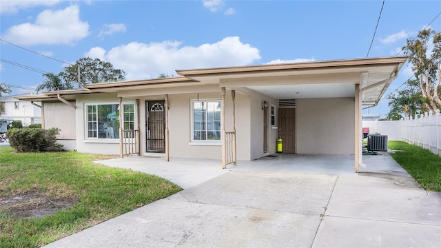 view of front of home with a carport, cooling unit, and a front yard