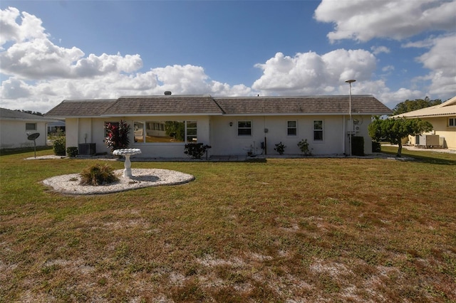 back of house with central AC and a lawn