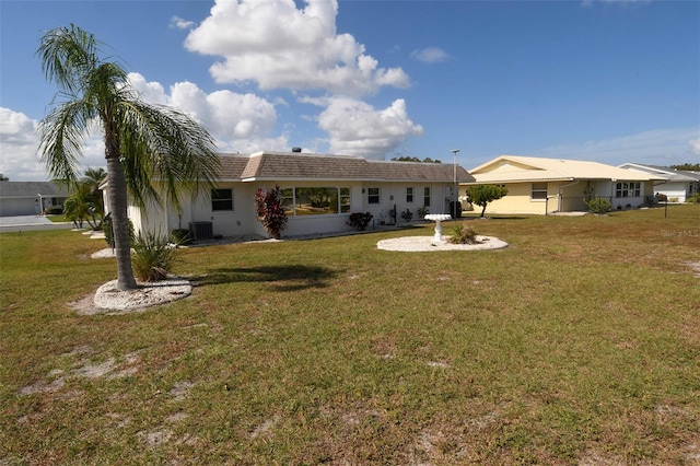 back of house featuring central AC and a yard