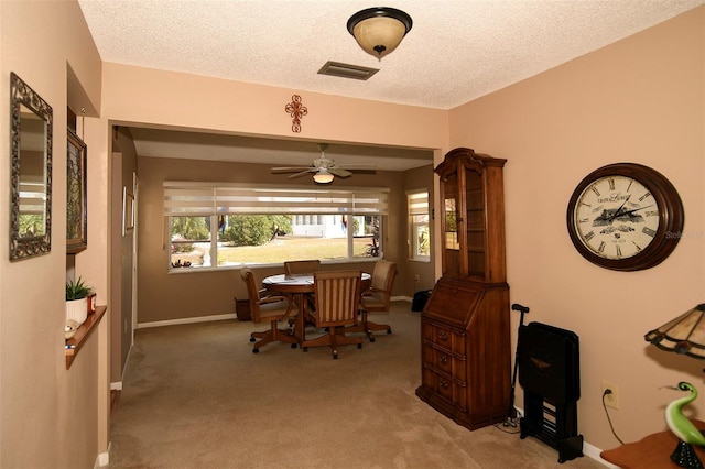 dining space with light carpet, a textured ceiling, and ceiling fan