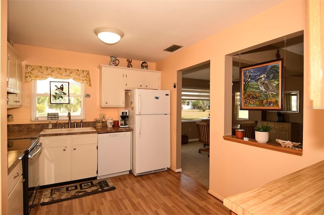 kitchen featuring light hardwood / wood-style flooring, white cabinets, sink, and white appliances