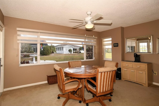 carpeted dining area featuring a textured ceiling and ceiling fan