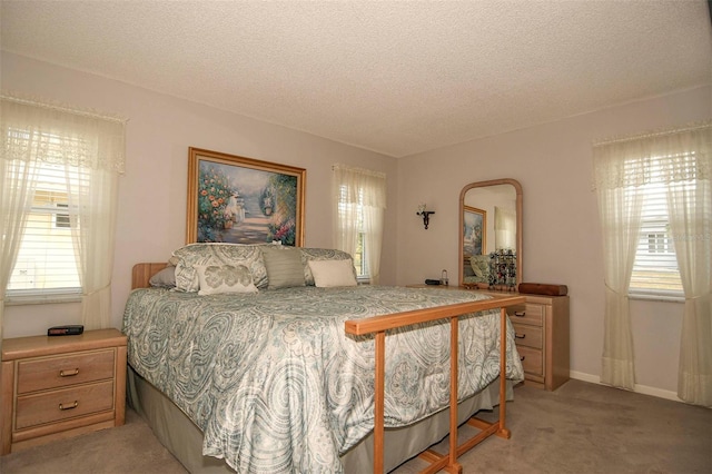 bedroom featuring a textured ceiling and light colored carpet