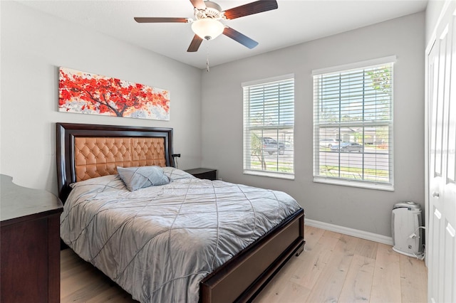 bedroom with light hardwood / wood-style flooring, a closet, and ceiling fan