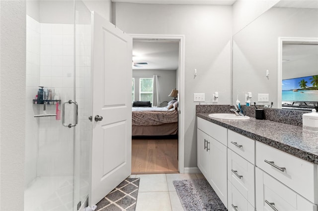 bathroom with vanity, walk in shower, ceiling fan, and tile patterned flooring