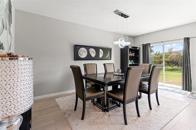 dining area featuring a chandelier, a textured ceiling, and light hardwood / wood-style floors