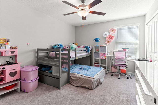 bedroom with a closet, ceiling fan, light carpet, and a textured ceiling