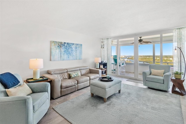 living room with a textured ceiling and ceiling fan