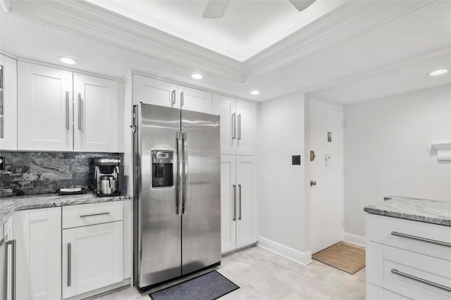 kitchen with stainless steel refrigerator with ice dispenser, white cabinetry, light stone countertops, and tasteful backsplash