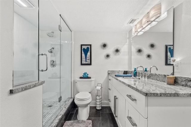 bathroom with vanity, toilet, a textured ceiling, and an enclosed shower