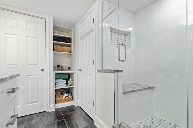 bathroom with a shower with shower door and tile patterned flooring