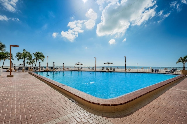 view of pool featuring a patio area and a water view