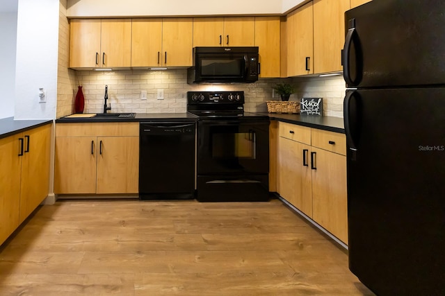 kitchen featuring tasteful backsplash, sink, black appliances, and light wood-type flooring