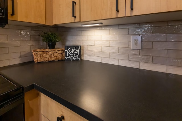 details featuring light brown cabinetry, backsplash, and black appliances