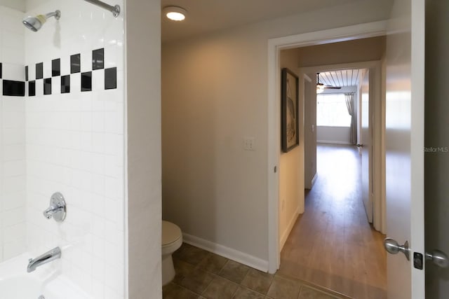 bathroom featuring toilet, hardwood / wood-style floors, and tiled shower / bath