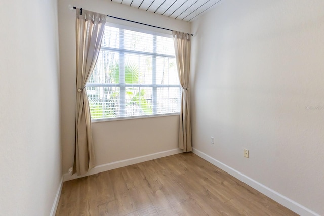 spare room featuring light hardwood / wood-style flooring and plenty of natural light