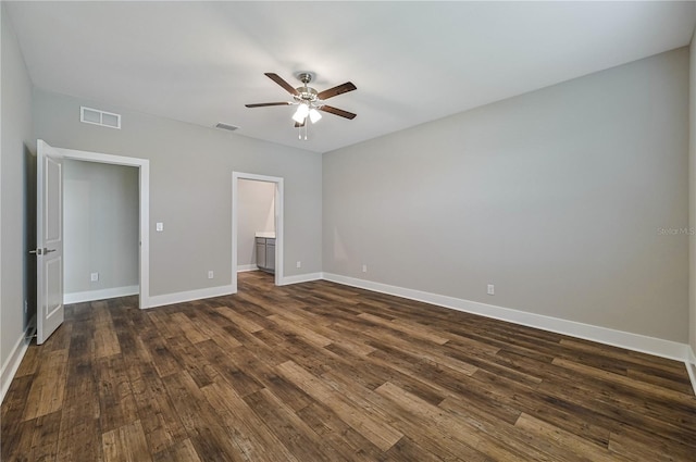 unfurnished bedroom featuring ceiling fan, dark wood-type flooring, and ensuite bath